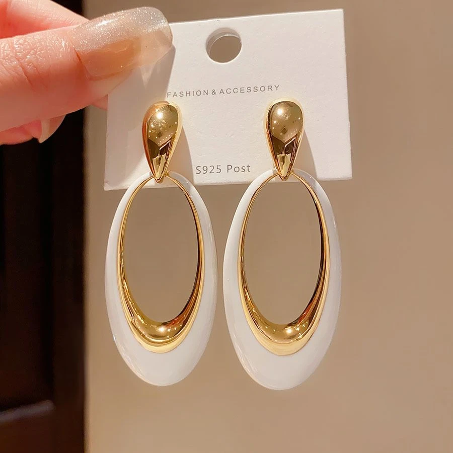 gold-accented white enamel and resin oval drop earrings